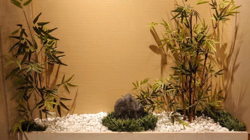 坪庭に石と竹の笹を植えて和モダンでおしゃれな雰囲気の庭の写真