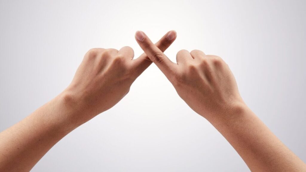 指でバツ印を作っている画像