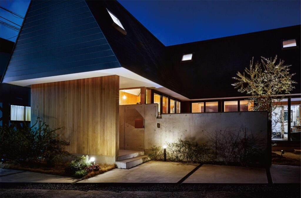 モダン住宅の玄関をポールライトでライトアップしている画像