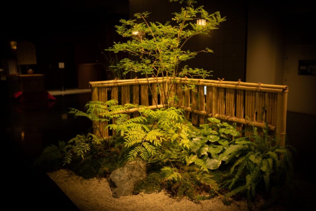 坪庭に庭石、植栽を竹垣で囲みライトアップしている写真