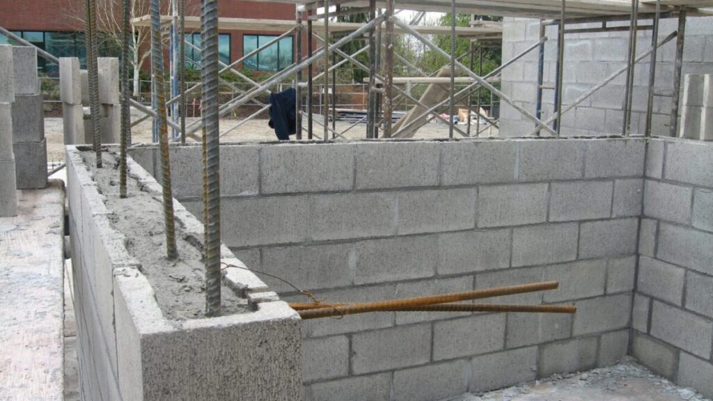 鉄筋を通してコンクリーとブロックを施工している工事現場画像