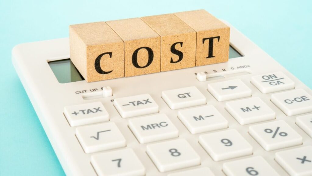 電卓の上にCOSTと書かれたブロックが置かれている画像