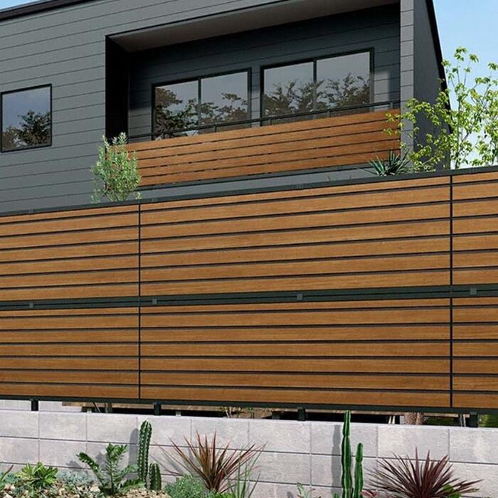 隙間なく完全目隠しになっている木目調の人工フェンスが設置してあるモダン住宅の写真